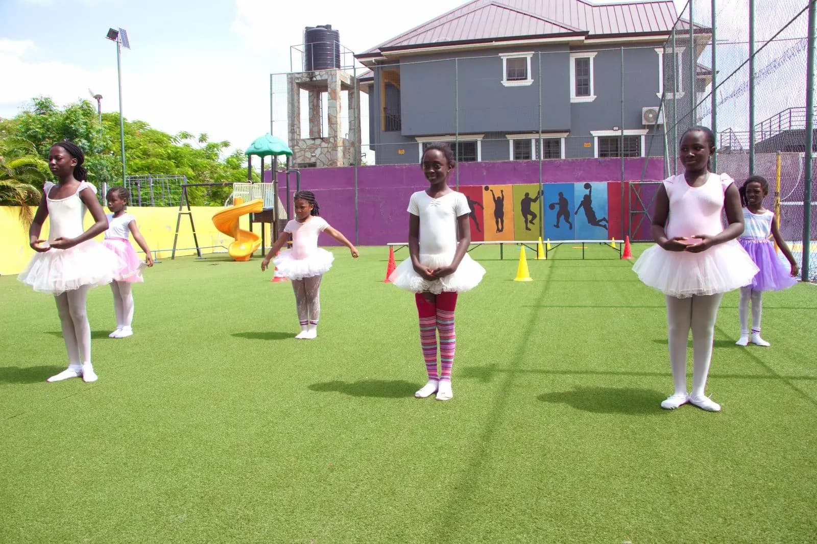 HABIS pupils in white and pink ballet outfits performing on the school field