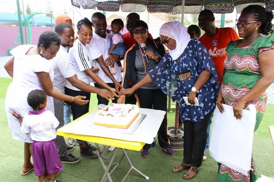 Staff and families cutting a celebration cake