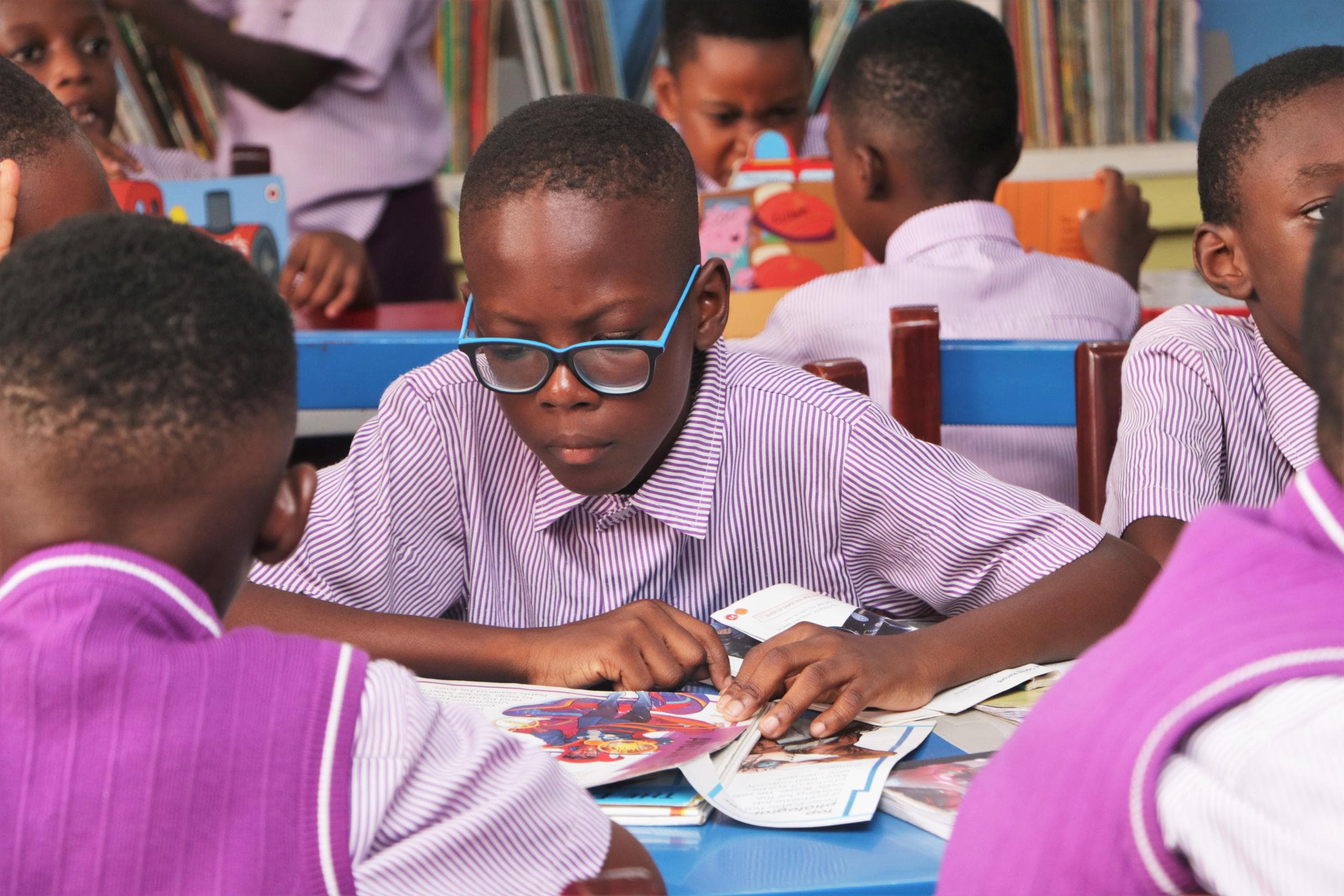 A HABIS pupil reading closely at a library table