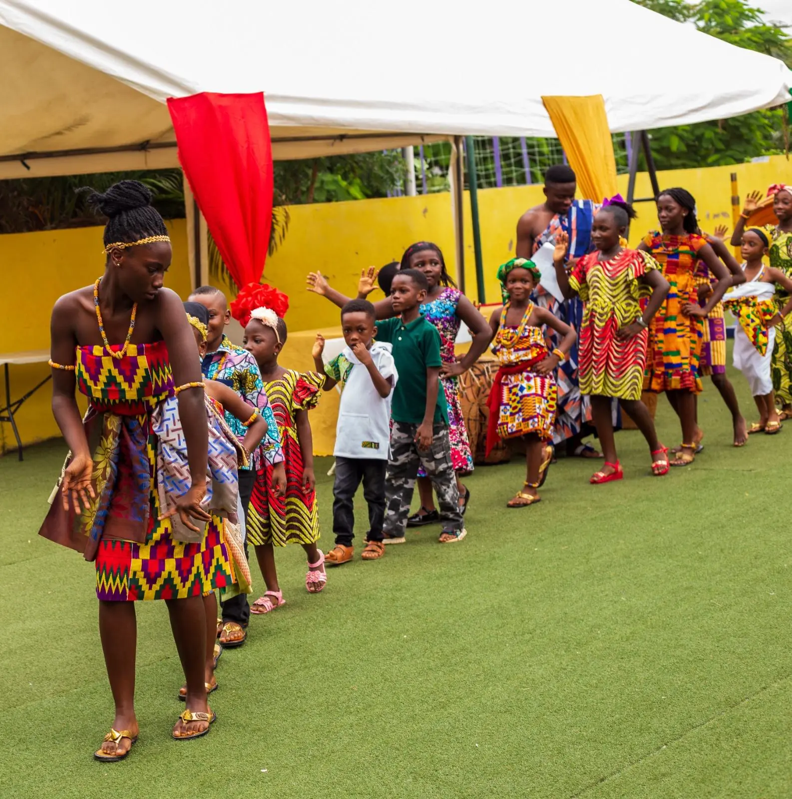 Young HABIS pupils lined up in traditional dress during an outdoor performance